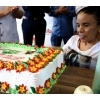 Usuária da FCEE corta o bolo de aniversário da instituição