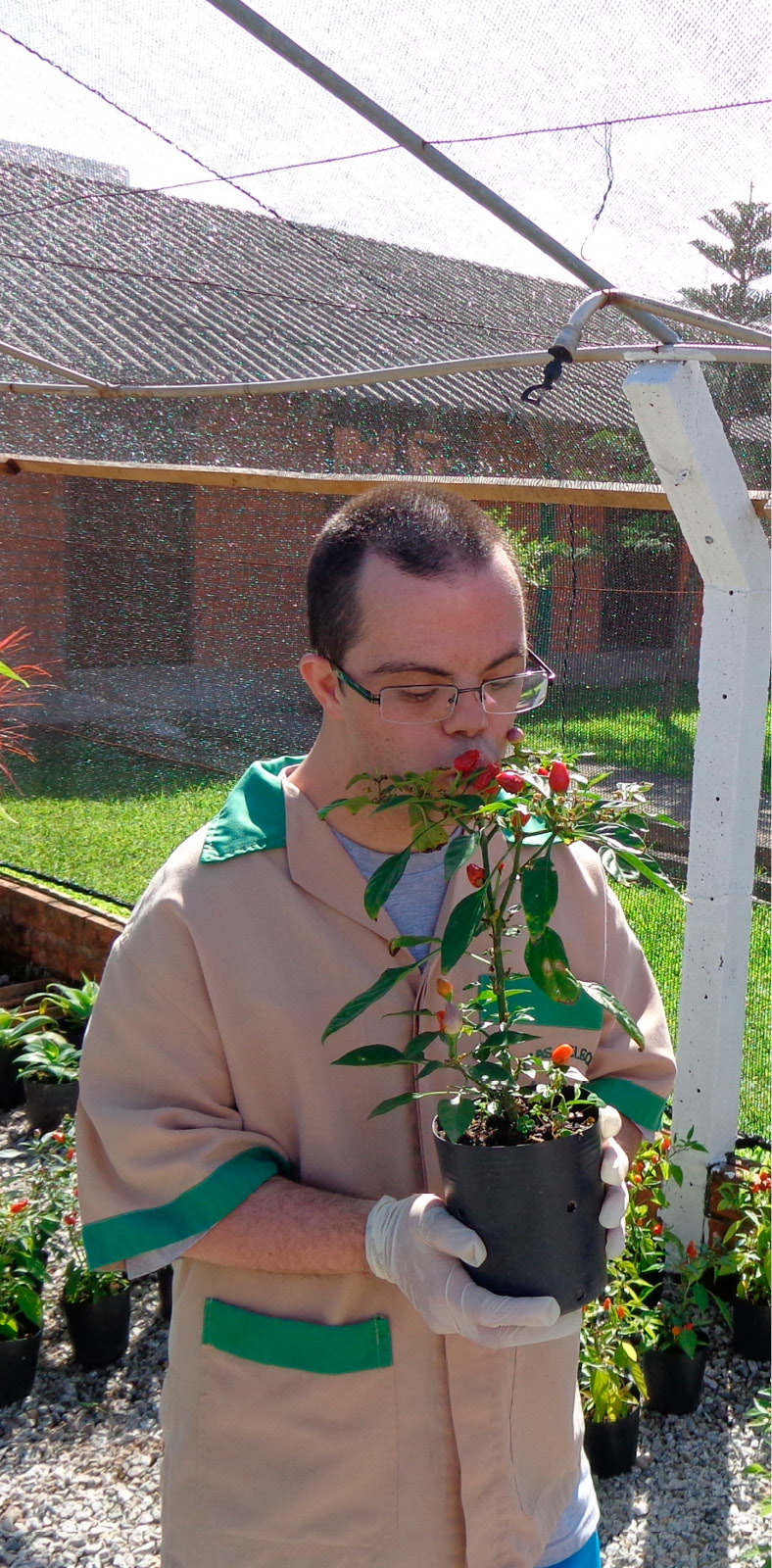 Educando da FCEE com trajes de jardineiro beija muda de planta