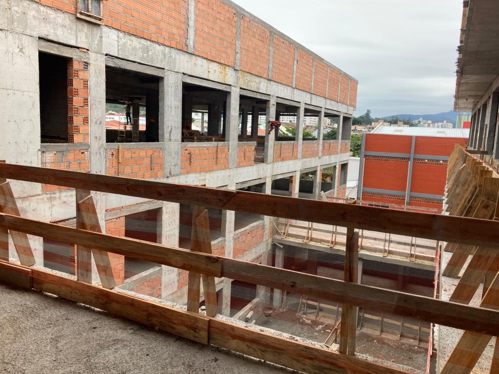 imagem de obra vista de dentro, pisoem cimento, paredes em tijolo