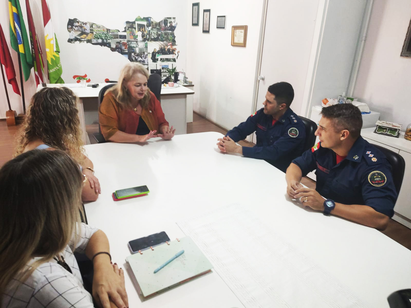 Cinco pessoas sentadas, sala de reunião, ambiente interno