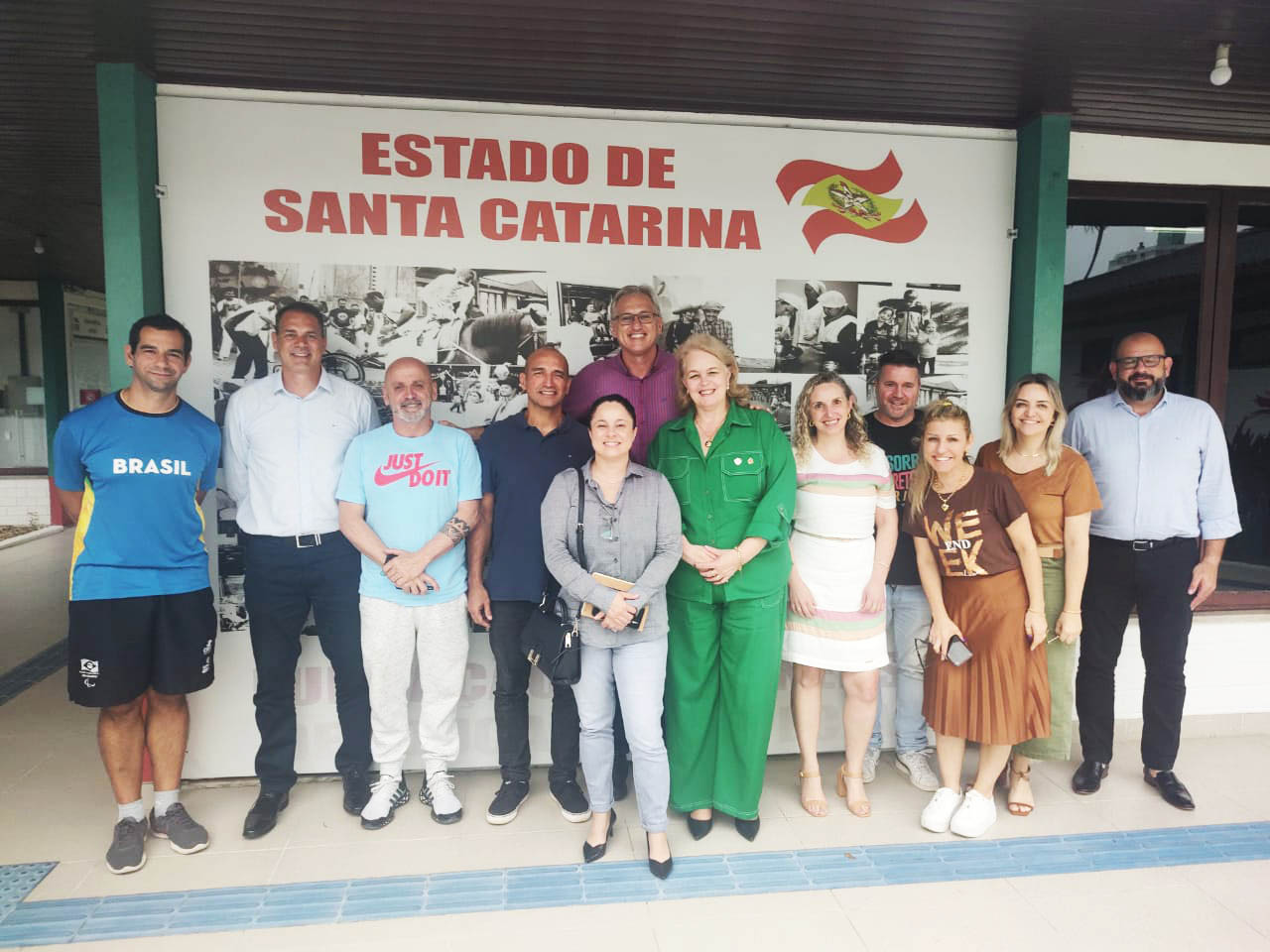 Imagem de 10 pessoas ao fundo letreiro Estado de Santa Catarina