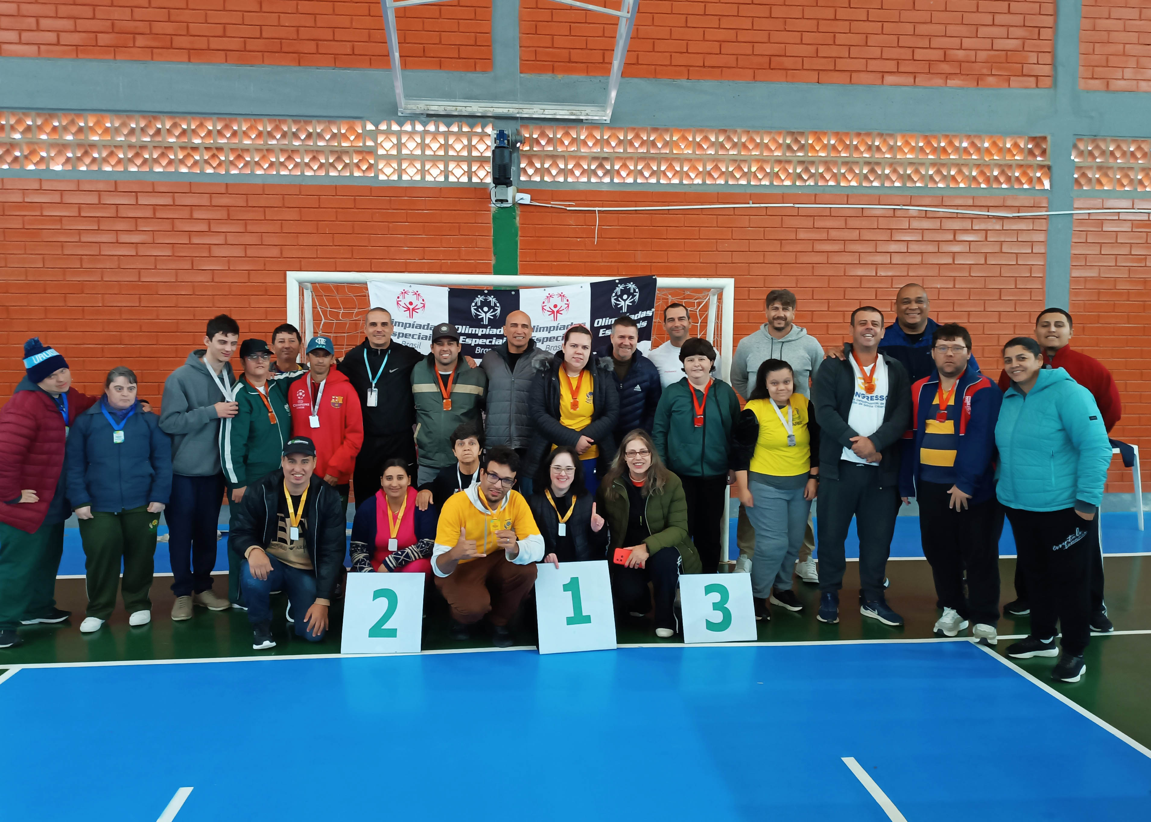Participantes do Campeonato de Tênis de Mesa trinta pessoas posam para foto em ginásio